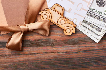 Money and ribbon bow. Pyrography car and blank paper. Posh and rich gift.の写真素材