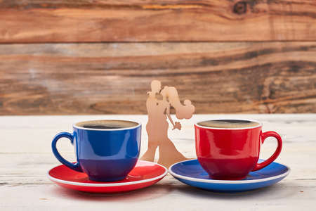 Wooden shape couple and cups. Mugs on saucers. Find a minute for coffee.の写真素材