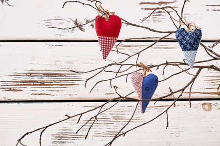 Branch with textile hearts. Fabric hearts with bows. Showing love through handmade gift.の写真素材