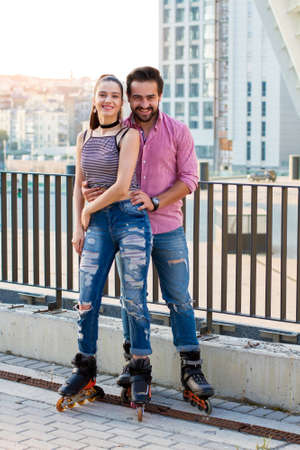 Couple on roller blade smiling. People on city background. Sport and romance.の写真素材