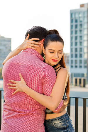 Young woman hugs man. Two people on city background. Feelings get stronger every day.の写真素材
