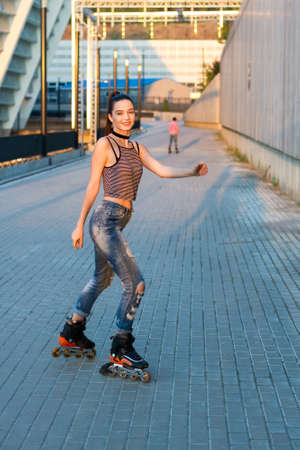 Woman rollerblading and smiling. Young lady on urban background. Wanna ride with me.の写真素材