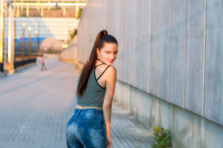 Smiling female on urban background. Young woman looking back. Pure beauty and youth.の写真素材