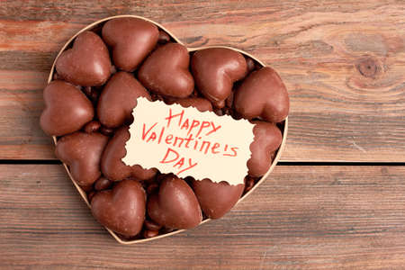 Chocolates in heart-shaped box. Valentines Day card on candies. Traditional sweet gift.の写真素材