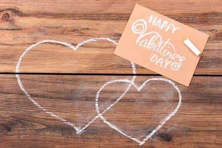 Greeting card near drawn hearts. Valentines Day card and chalk. Symbol of love.の写真素材
