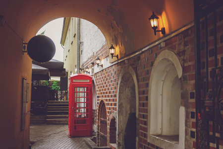 Red phone booth. Telephone kiosk near building. Keep connection to the world.の写真素材