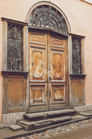 Old doors and windows. Building with wrought iron ornament. Entrance to abandoned house.の写真素材