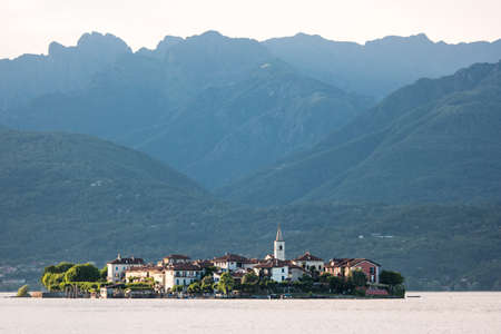 Island on high mountains background. Buildings near water. Live amidst the sea.の写真素材