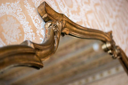 Mirror in old gilded frame. Antique frame on the wall. Art and time.の写真素材