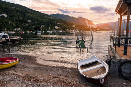 Water, mountains and boats. Rowboat on the shore. Find nice place for fishing.の写真素材