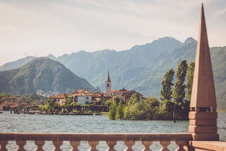 Mountains and town buildings. Water and green trees. Isola Superiore in summer.の写真素材