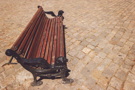 Bench on pavement background. Wooden and iron bench. Sit back and relax.の写真素材