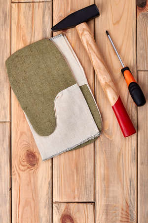 Hammer and screwdriver on wood. Work gloves near tools. How to become a handyman.の写真素材