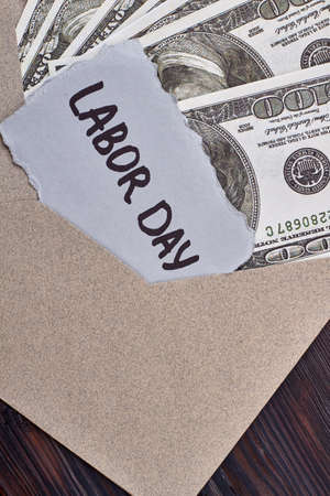 Labour Day card near dollars. Envelope with money and card. Reward for hard work.の写真素材