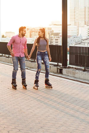 Couple rollerblading and holding hands. People on daytime city background. Lets go for a ride.の写真素材