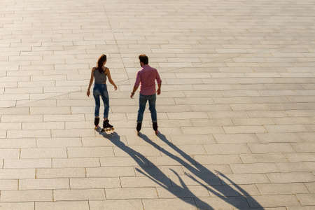 Back view of rollerblading couple. Man and woman outdoors. Our new active hobby.の写真素材