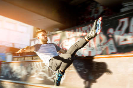 Guy on rollerblades doing trick. Young rollerblader outdoor. Speed and balance.の写真素材