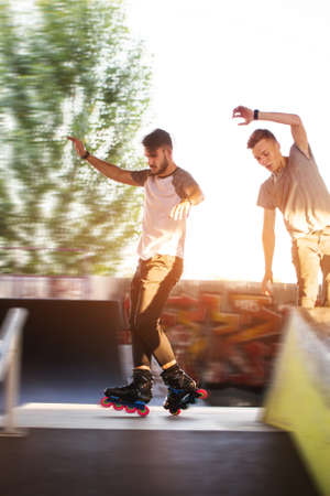 Young people rollerblading. Two guys outdoor. Friends in skate park.の写真素材
