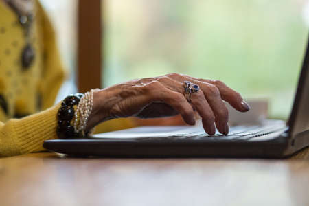 Senior womans hand and laptop. Person with notebook pc indoor. Step into era of technologies.の写真素材