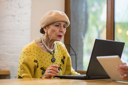 Old woman with laptop. Senior lady indoors. Fix problems with os.