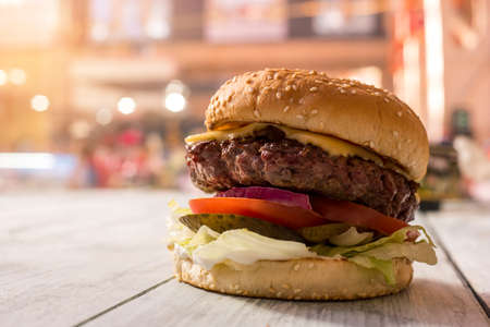 Hamburger on gray wooden surface. Side view of a burger.の写真素材