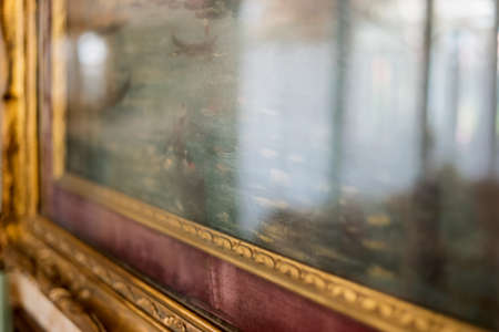 Old frame with painting. Gilded frame with ornament. The museum exhibit.の写真素材