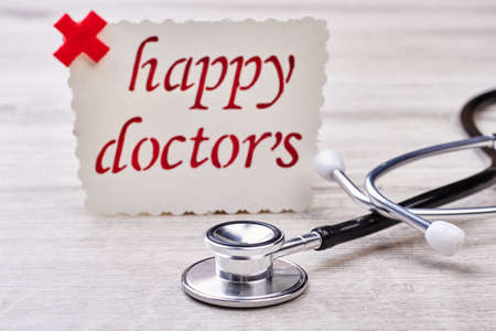 Card for Doctors Day. Stethoscope on gray wooden surface.の写真素材