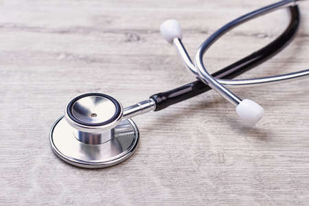 Stethoscope lying on wooden table. Medical cardiac instrument.の写真素材