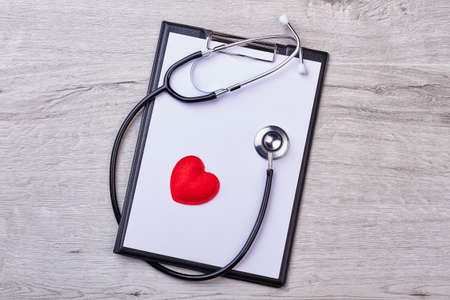 Stethoscope with a clipboard. Blank paper and red heart.の写真素材