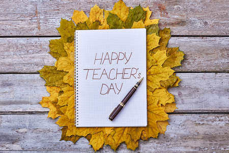 Dry leaves, pen and notebook. Teachers Day celebration.