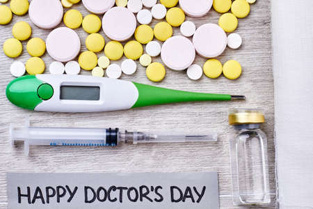 Colorful pills and medical instruments. Warm congratulation with Doctors Day.