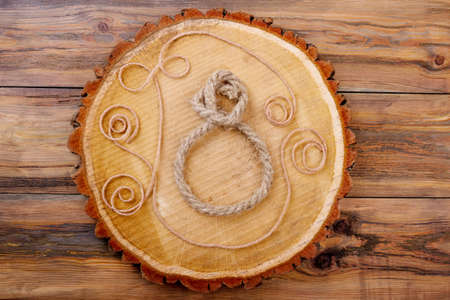 8-shaped rope on trunk slice. Rope patterns on wood. Use available materials for craft. Original handmade gift.の写真素材