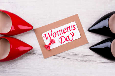 Shoes, bow tie, and postcard. Womans Day greeting card. Congratulate and give greeting cards. Holiday shiny footwear.の写真素材