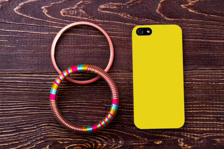 Bracelet near phone. Smartphone and accessory on wood. Connection of life and technology....
