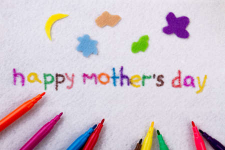 Happy Mothers Day inscription. Felt-tip pen on cloth background. Congratulate mother with present. Make it colorful.の写真素材