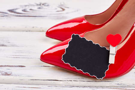 Female red shoes on white. Present from heart.の写真素材