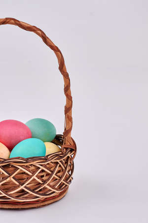Isolated basket with colored eggs. Easter wicker basket.の写真素材