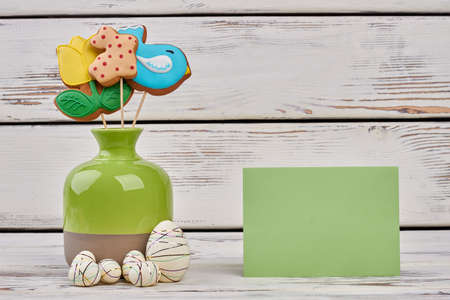 Vase and blank greeting card. eggs on wooden surface. Be kind and wish best.の写真素材