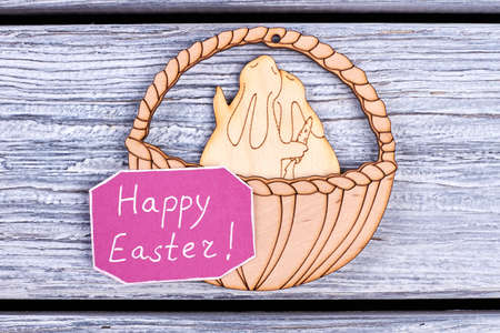 Plywood bunnies and basket. Easter congratulatory card. Wishes for Easter holiday.の写真素材