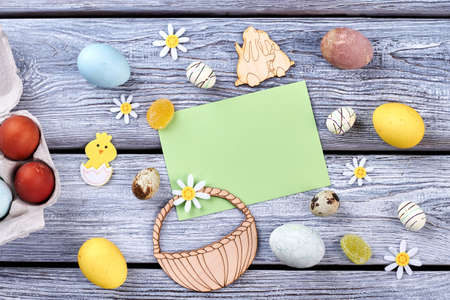 Colored eggs and plywood figurines. Paper card and candies. Compilation of traditional Easter items.の写真素材