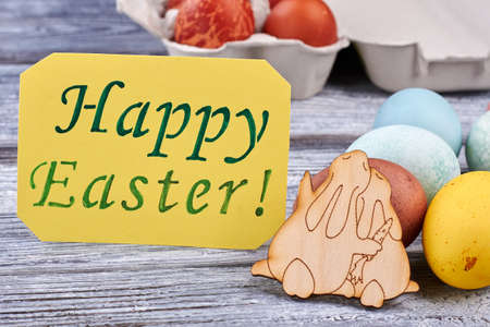Easter eggs on wooden surface. Plywood bunnies and Easter card. Joyous Easter mood.の写真素材
