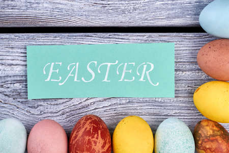 Easter greeting card and eggs. Painted eggs on gray wood. How to celebrate Easter.の写真素材