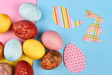 Bright colored Easter eggs. Rabbit and bird paper cutout. Colors of spring.
