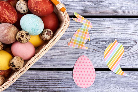 Easter cutouts on gray wood. Egg basket, top view. Faith, traditions and art.