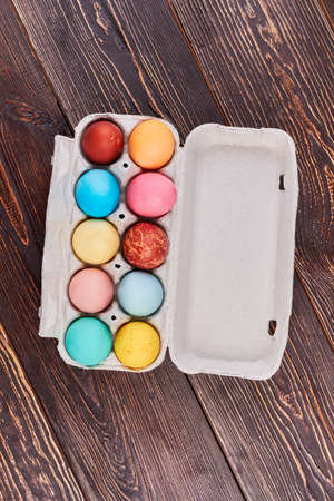 Easter egg tray, brown wood. Top view of painted eggs. Simple Easter food ideas.