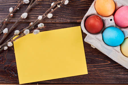 Easter eggs, blank yellow card. Willow branches on brown wood. Best ideas for Easter congratulations.の写真素材
