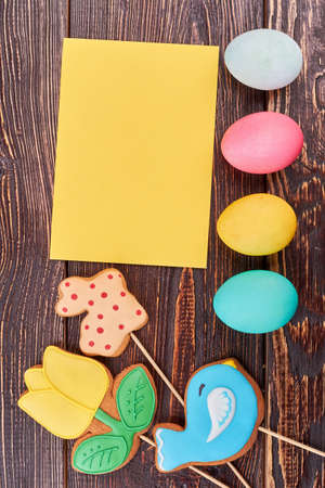 Blank yellow card, Easter eggs. Bright cookies on sticks. Original recipes for Easter sweets.