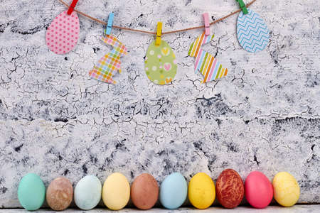 Row of colored Easter eggs. Paper cutouts on a rope. Easter home decor.の写真素材
