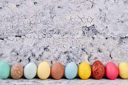 Row of Easter eggs. White painted wood surface.の写真素材