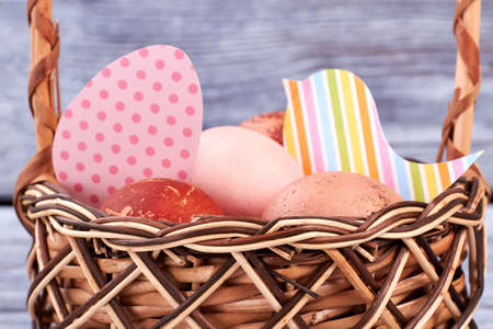 Eggs and colorful paper cutouts. Easter basket close up.